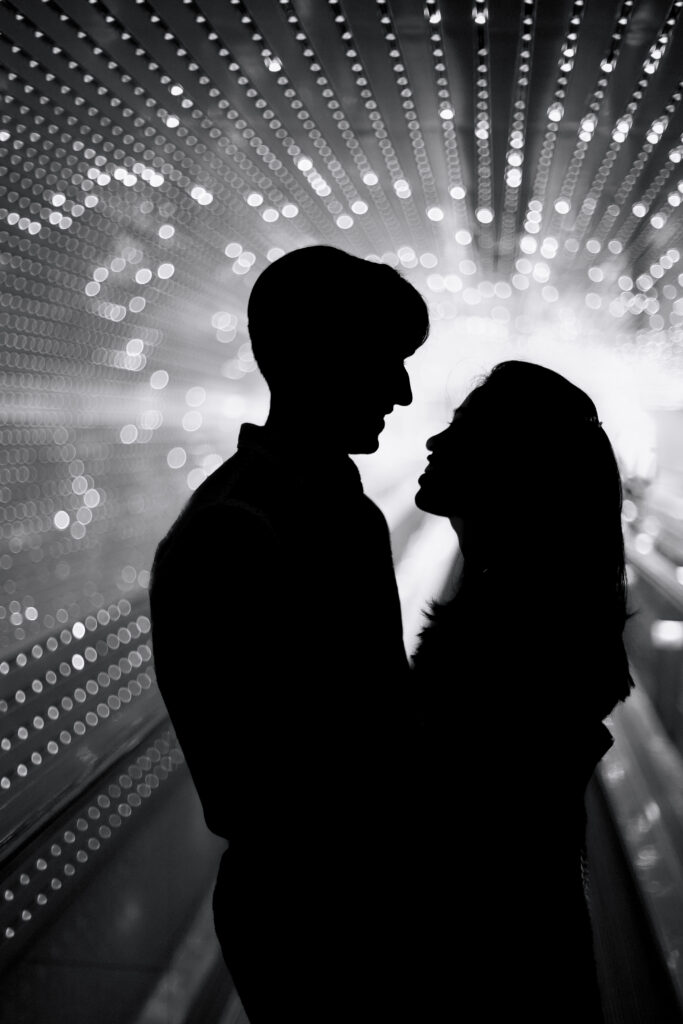 The silhouette of a man and woman, backlit by dozens of LED lights